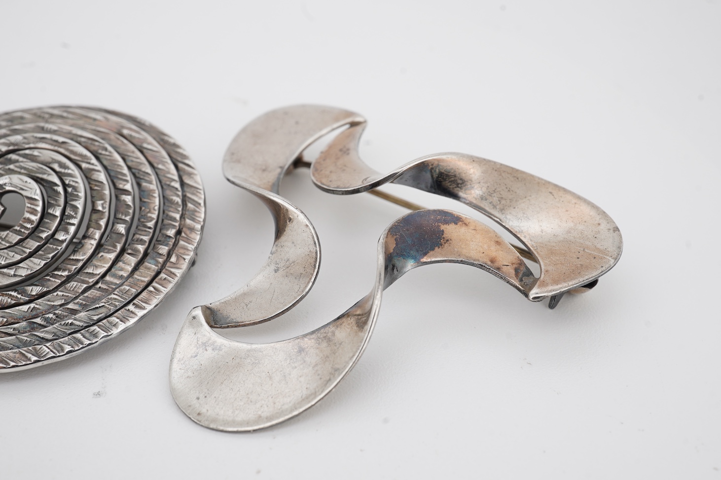 A mid to late 20th century Danish sterling tri-form brooch and a 925S ring by by Carl Ove Frydensberg, brooch, 43mm and a 1970's Finnish 925 circular brooch, by Kuppittaan Kulta, Turku, diameter 36mm.